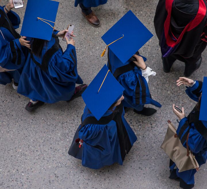 Studenter i blå kappe og hatt sett ovenfra